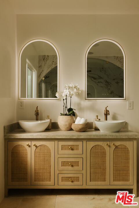 880 Teakwood Road Los Angeles, CA 90049 - Photo 18 of 38 a bathroom with a granite countertop double vanity sink and mirror