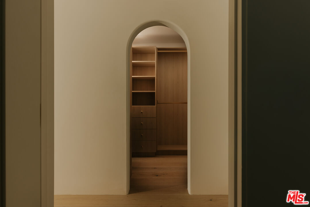 880 Teakwood Road Los Angeles, CA 90049 - Photo 21 of 38 a view of a hallway with wooden shelves