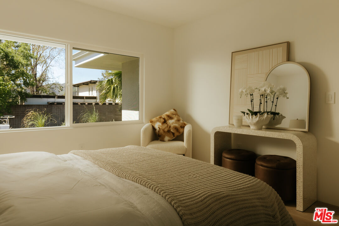 880 Teakwood Road Los Angeles, CA 90049 - Photo 26 of 38 a bedroom with a bed and a painting on the wall