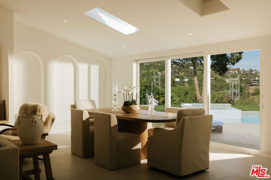 880 Teakwood Road Los Angeles, CA 90049 - Photo 8 of 38 a dining room with furniture and large windows