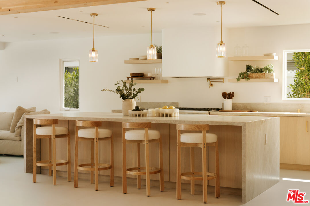880 Teakwood Road Los Angeles, CA 90049 - Photo 10 of 38 a kitchen with a sink and chairs