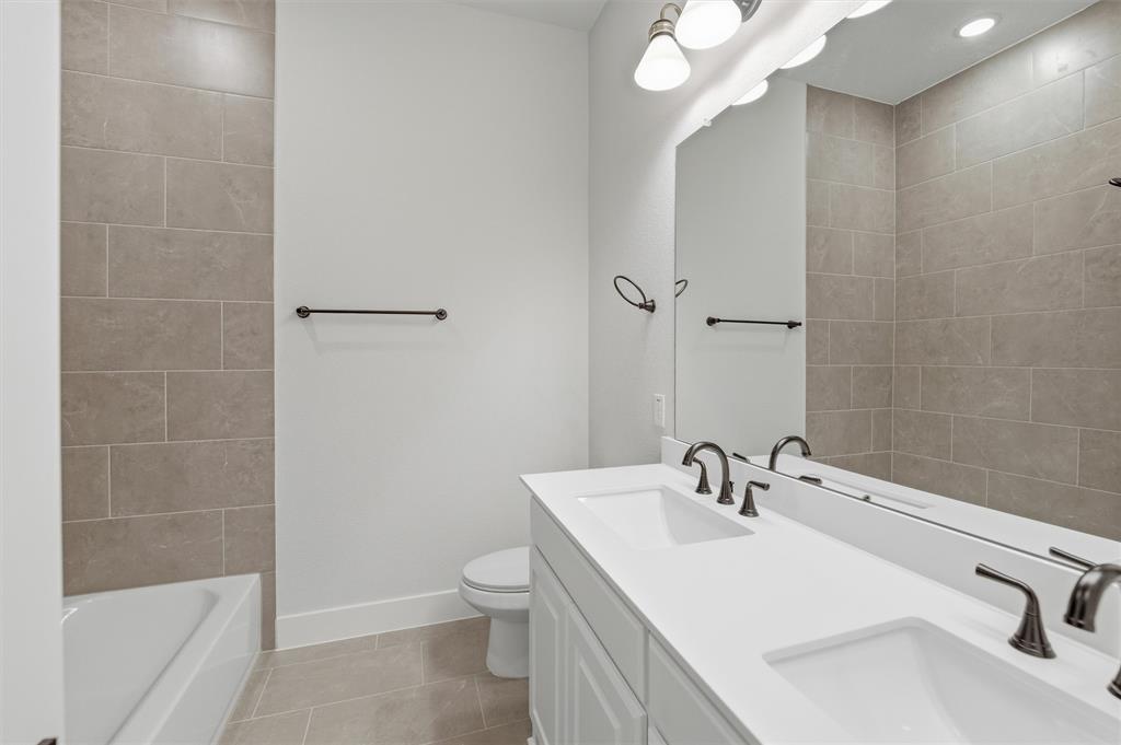 809 Vly Rdg Road Van Alstyne, TX 75495 - Photo 15 of 30 a bathroom with a sink a toilet and shower