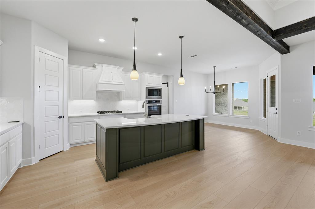 809 Vly Rdg Road Van Alstyne, TX 75495 - Photo 21 of 30 a kitchen with stainless steel appliances kitchen island a refrigerator and a wooden cabinets