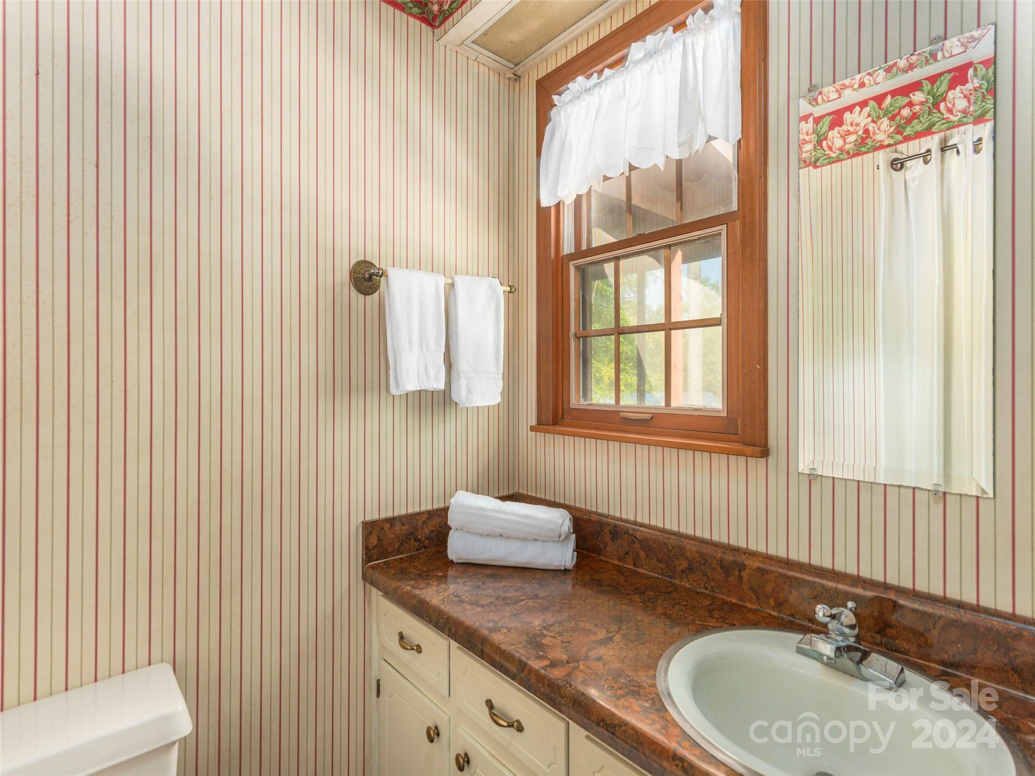 183 Reuben Branch Road Maggie Valley, NC 28751 - Photo 14 of 29 a bathroom with a granite countertop sink and a mirror