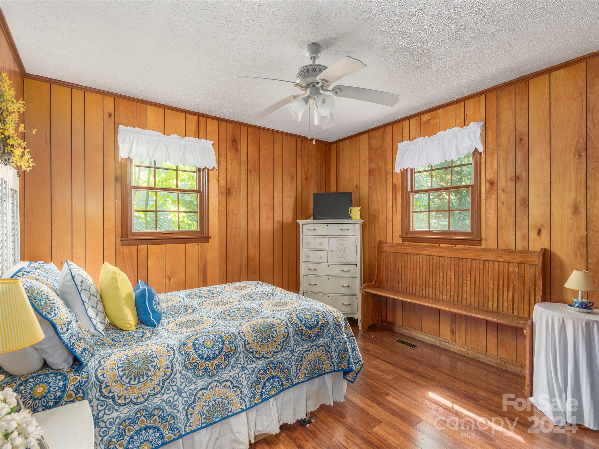 183 Reuben Branch Road Maggie Valley, NC 28751 - Photo 15 of 29 a bedroom with a large bed and a chandelier