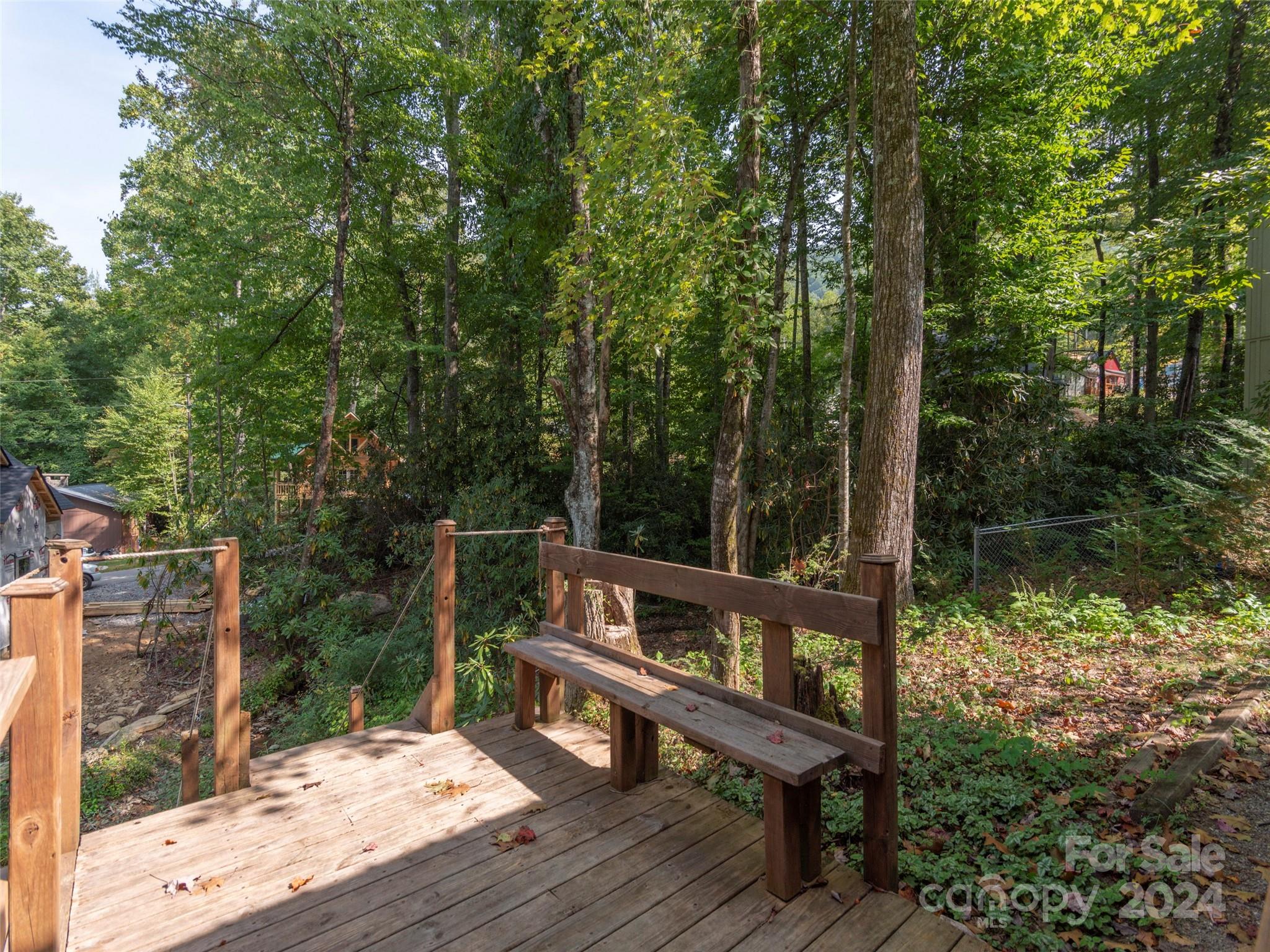 183 Reuben Branch Road Maggie Valley, NC 28751 - Photo 20 of 29 a view of a wooden deck with a bench