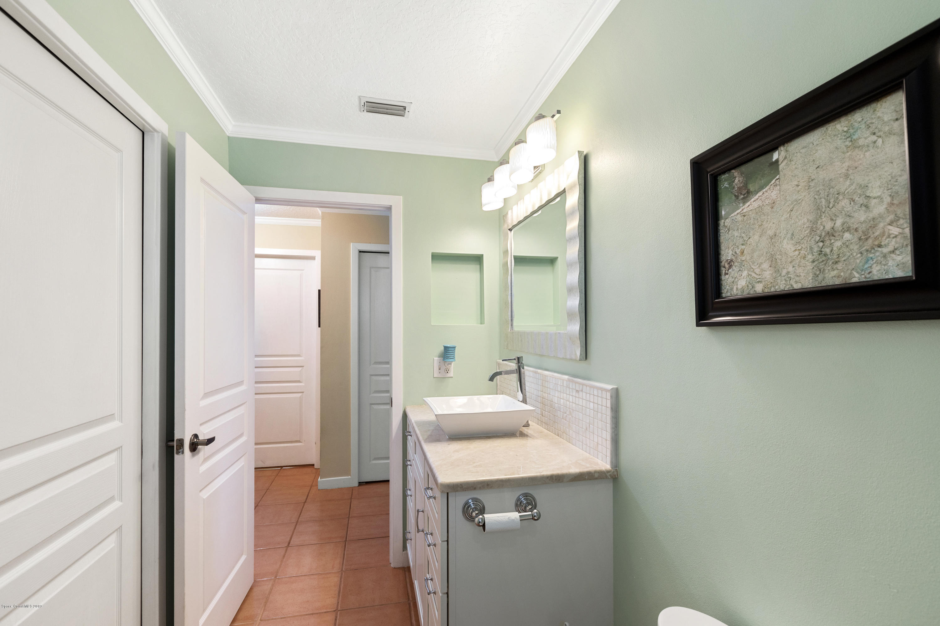 4231 Turtle Mound Road Melbourne, FL 32934 - Photo 17 of 39 a bathroom with a sink mirror and a shower