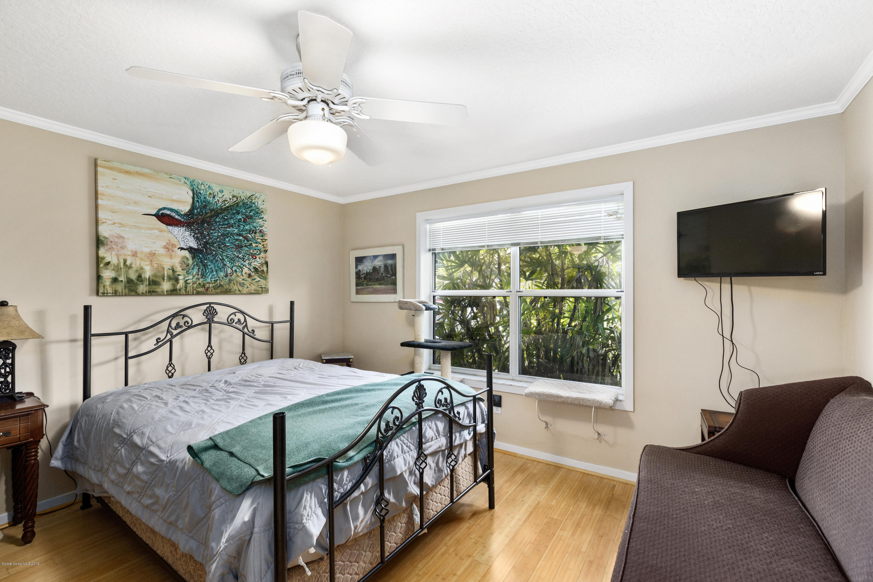4231 Turtle Mound Road Melbourne, FL 32934 - Photo 18 of 39 a bedroom with a bed and a flat screen tv