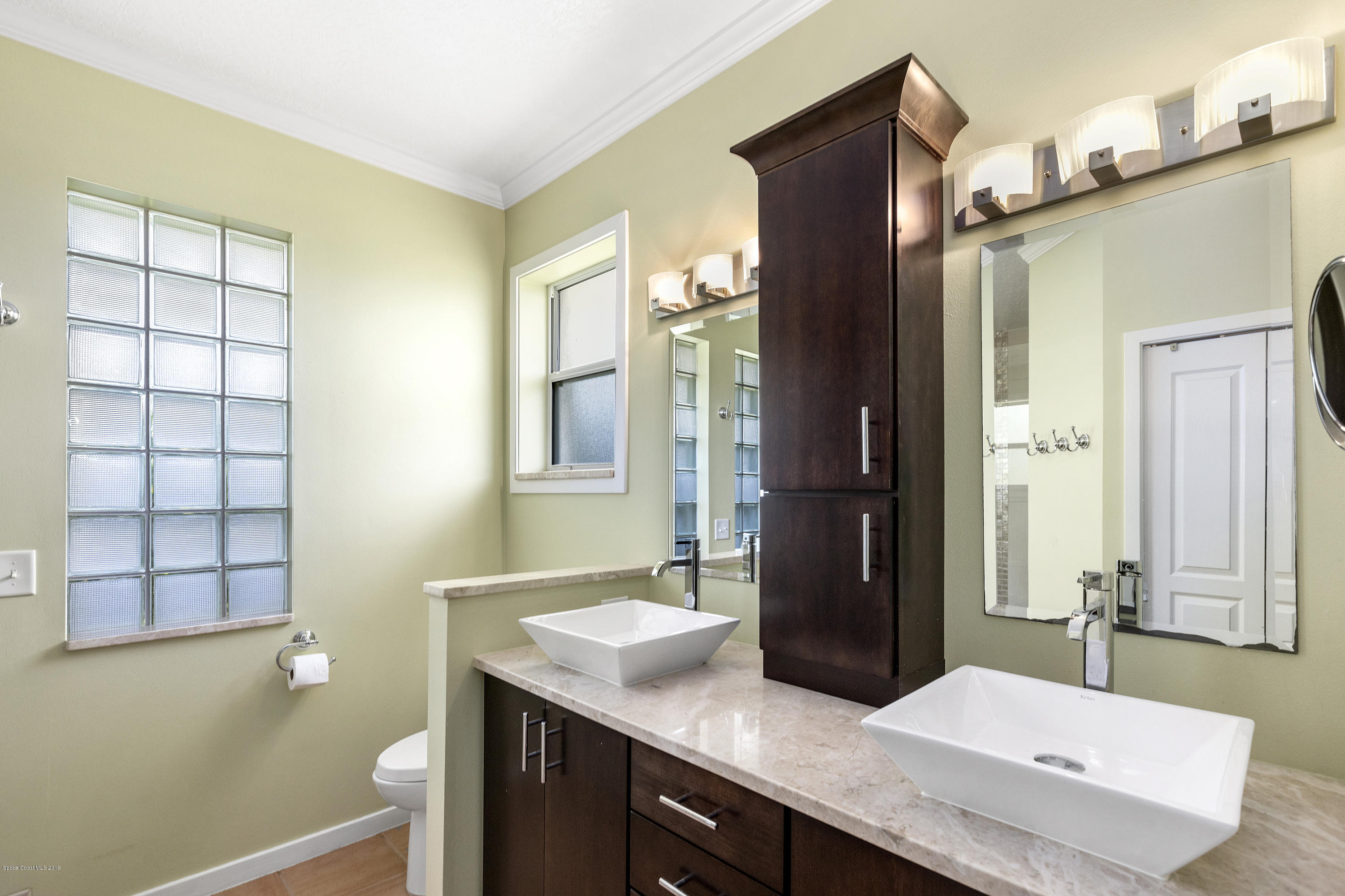 4231 Turtle Mound Road Melbourne, FL 32934 - Photo 21 of 39 a bathroom with a granite countertop sink a mirror and a shower