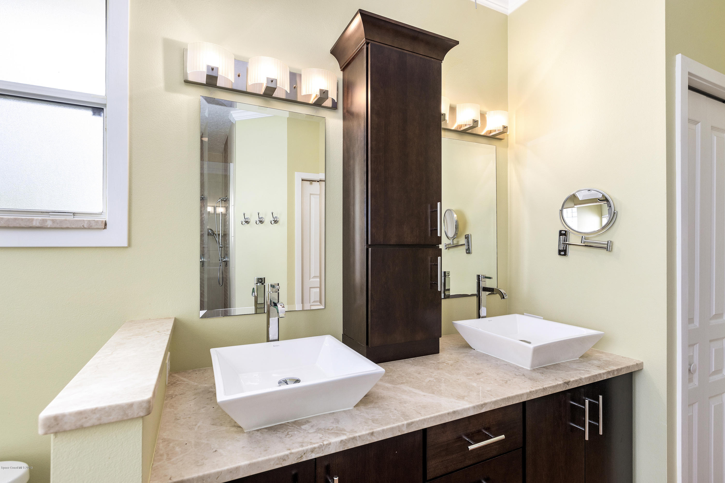 4231 Turtle Mound Road Melbourne, FL 32934 - Photo 24 of 39 a bathroom with a sink a mirror and a shower