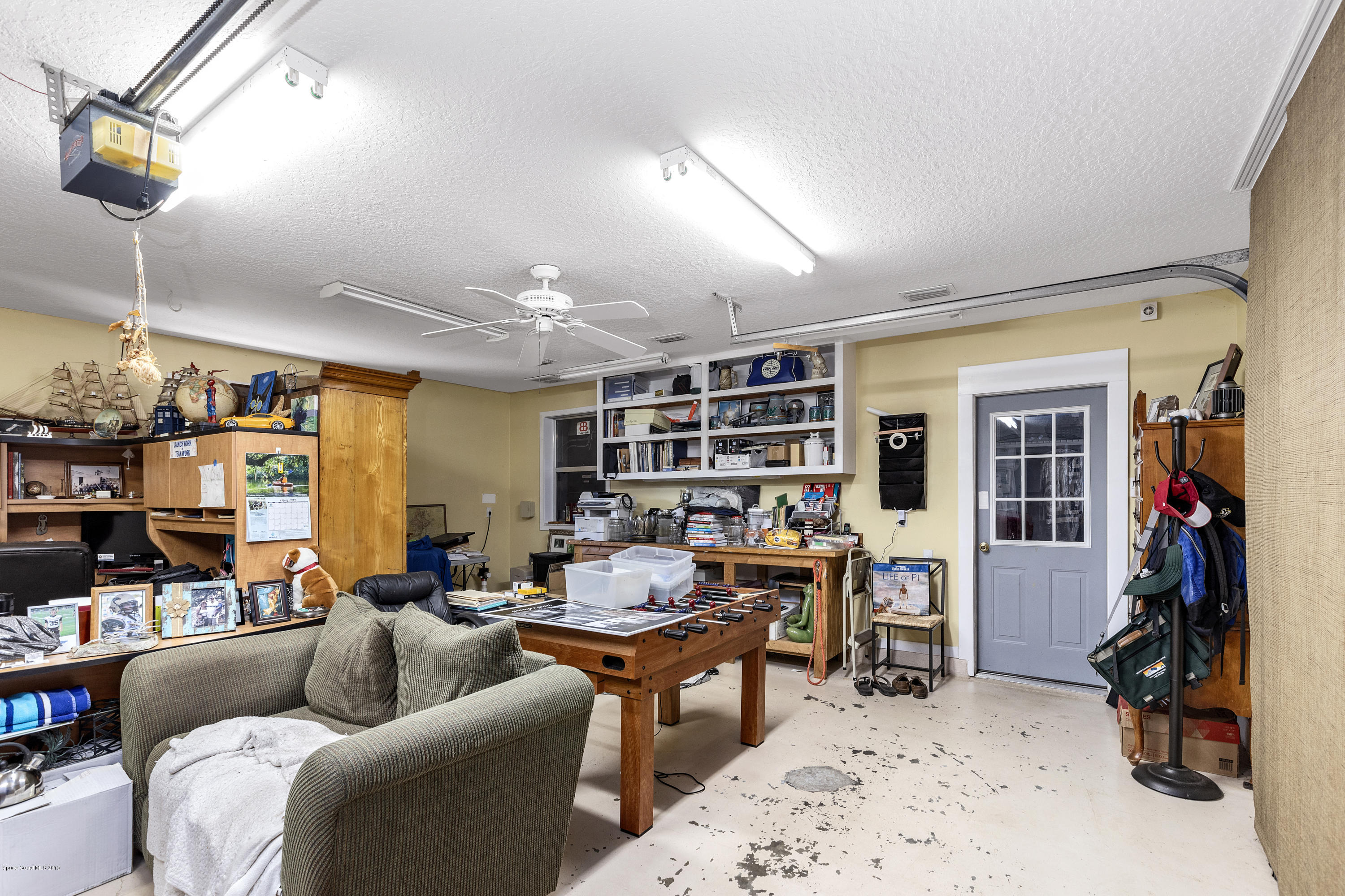 4231 Turtle Mound Road Melbourne, FL 32934 - Photo 27 of 39 a living room with furniture and a book shelf