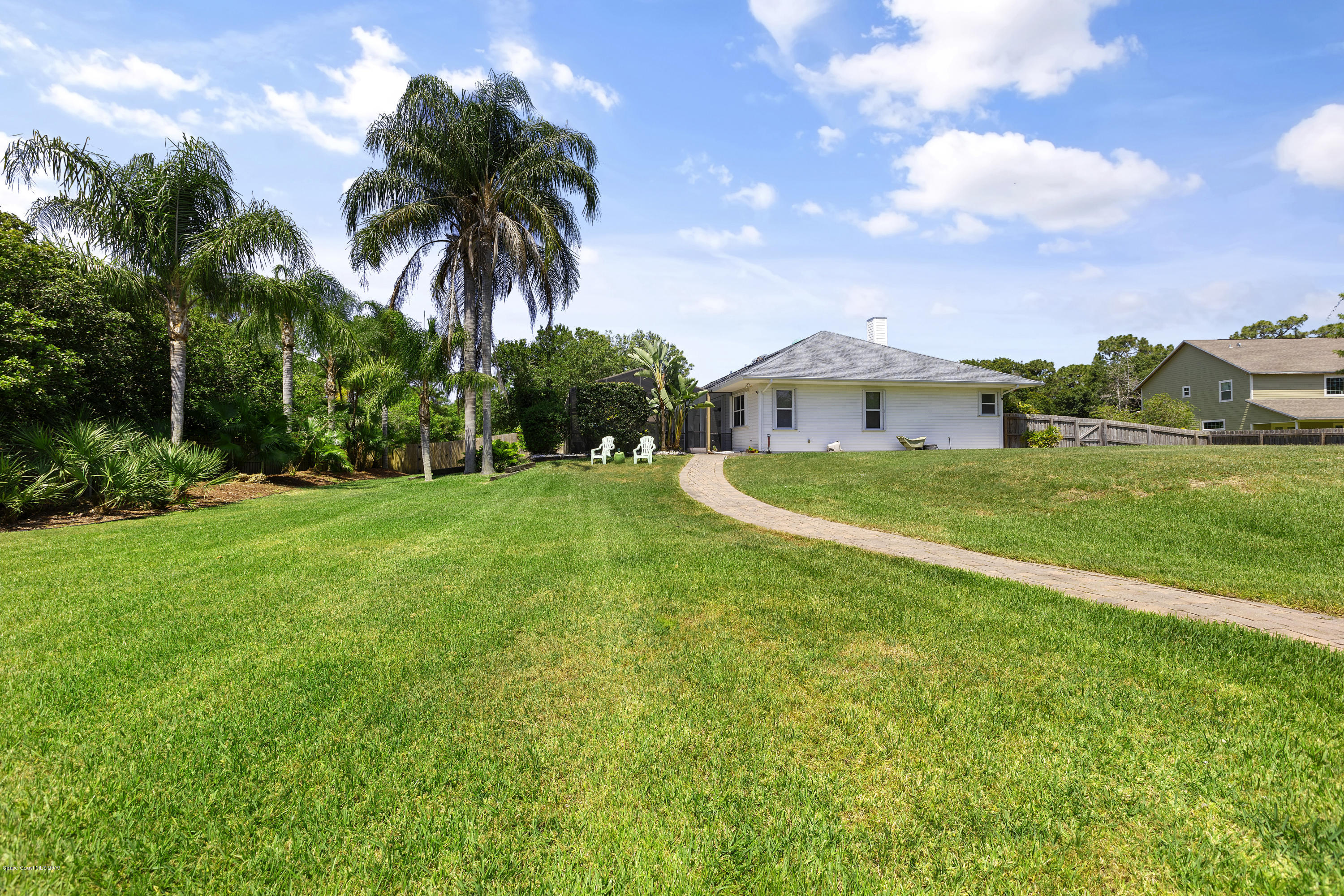 4231 Turtle Mound Road Melbourne, FL 32934 - Photo 37 of 39 a view of a house with a big yard and palm trees
