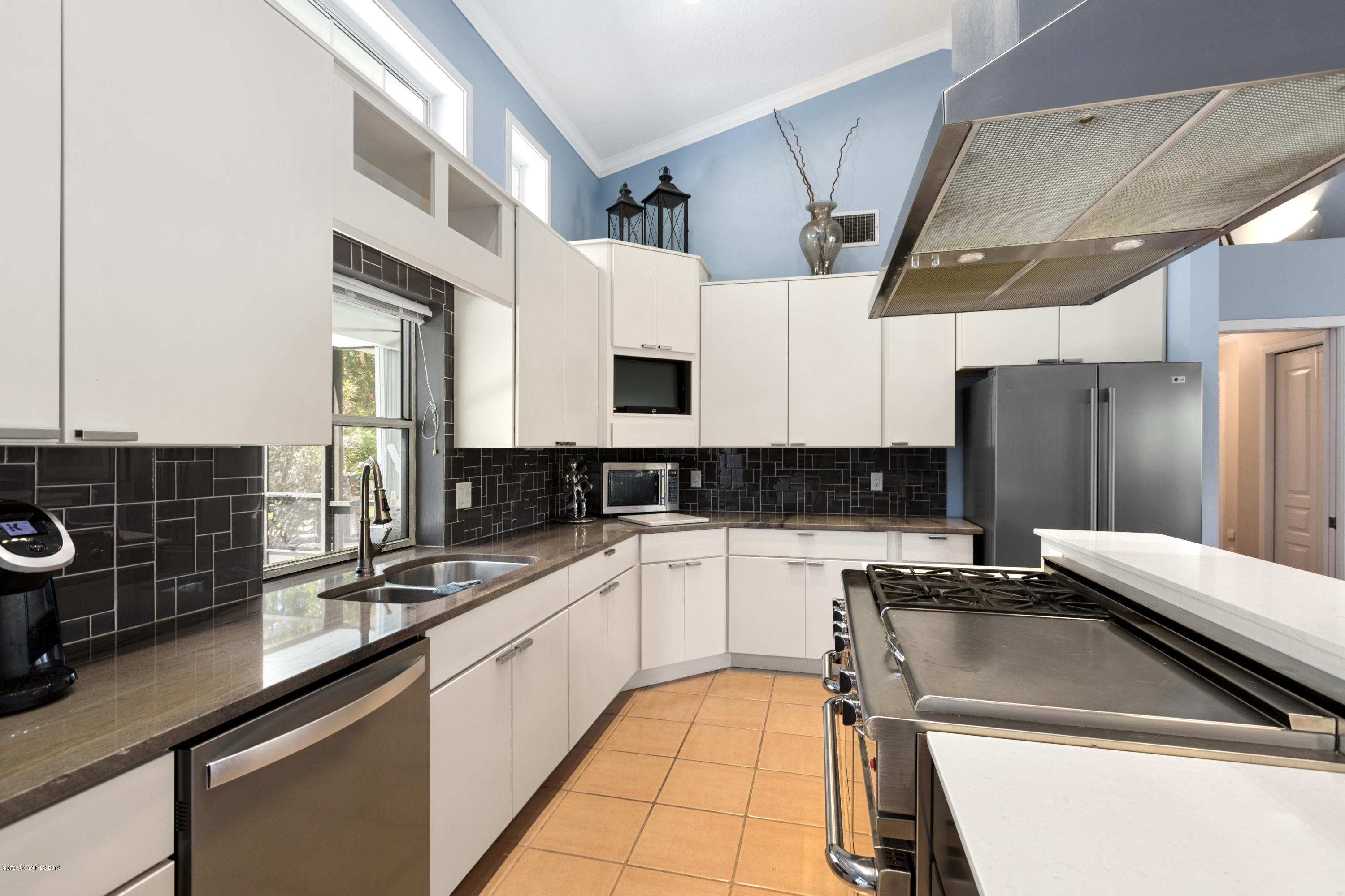 4231 Turtle Mound Road Melbourne, FL 32934 - Photo 6 of 39 a kitchen with a sink a counter top space cabinets and stainless steel appliances