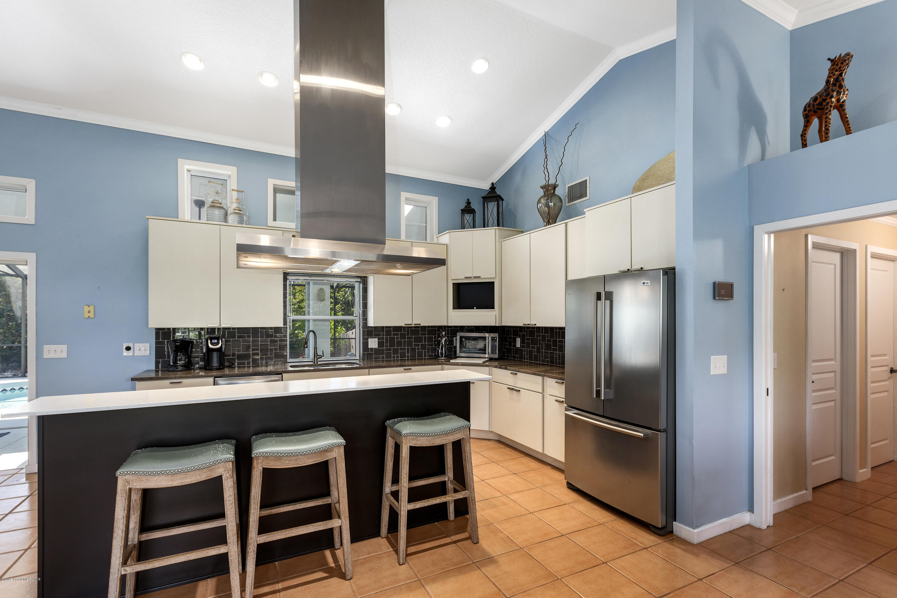 4231 Turtle Mound Road Melbourne, FL 32934 - Photo 10 of 39 a kitchen with stainless steel appliances a sink a stove a refrigerator and cabinets