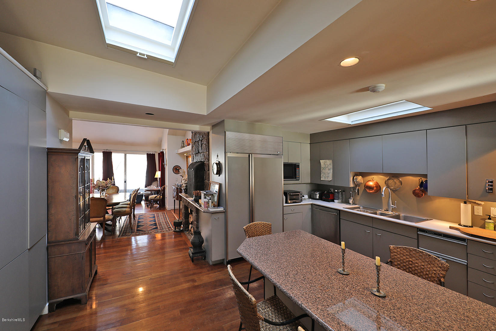 12 Red Rock Road West Stockbridge, MA 01266 - Photo 13 of 31 a kitchen with stainless steel appliances kitchen island granite countertop a refrigerator a stove a dining table and chairs with wooden floor