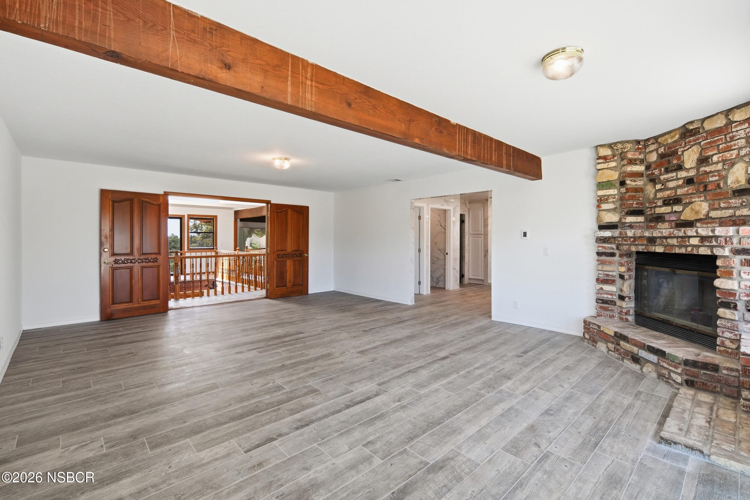 140 East Rice Ranch Road Santa Maria, CA 93455 - Photo 27 of 44 a view of an empty room with wooden floor and a fireplace