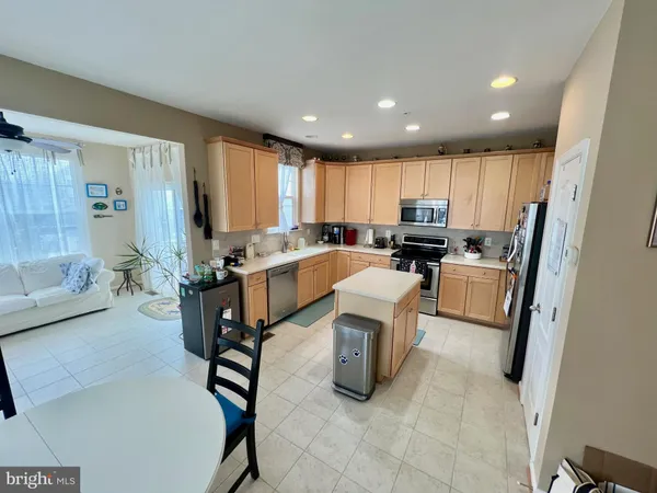 a open kitchen with granite countertop a stove a sink a dining table and chairs