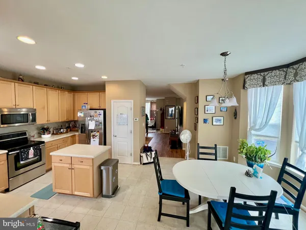 a kitchen with a table chairs refrigerator and microwave