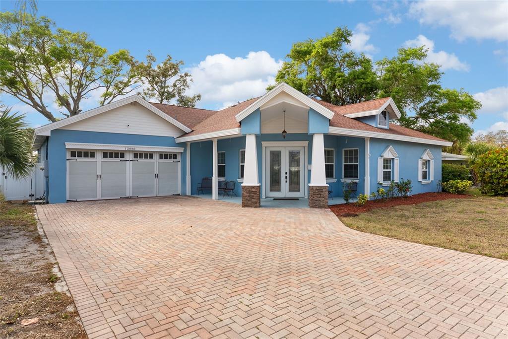 12080 143rd Street North Largo, FL 33774 - Photo 6 of 49 a front view of a house with a garden and trees