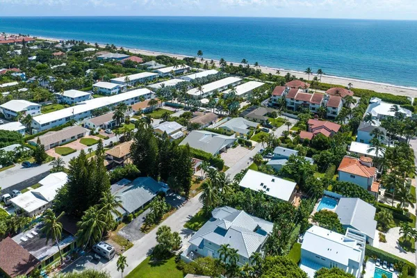 an aerial view of residential houses with outdoor space and trees