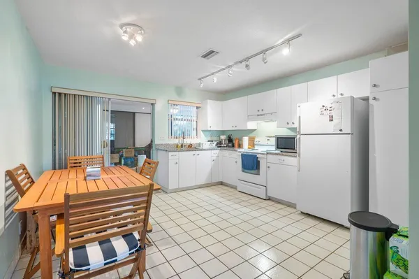 a kitchen with white cabinets and appliances