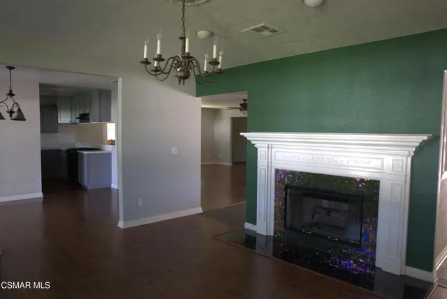 a view of a livingroom with a fireplace a chandelier