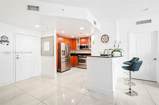 a kitchen with stainless steel appliances granite countertop a refrigerator and a stove top oven