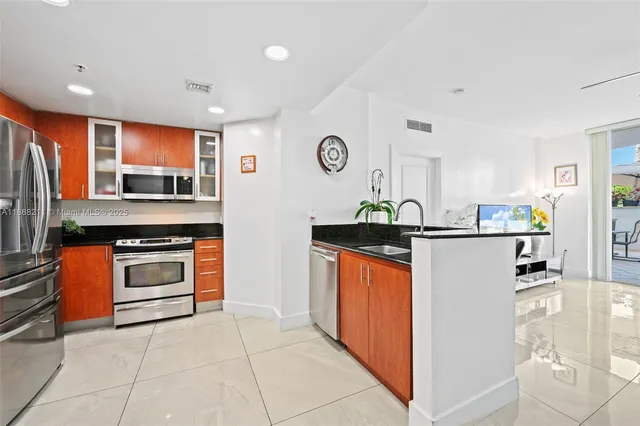 a kitchen with stainless steel appliances granite countertop a refrigerator and a stove top oven