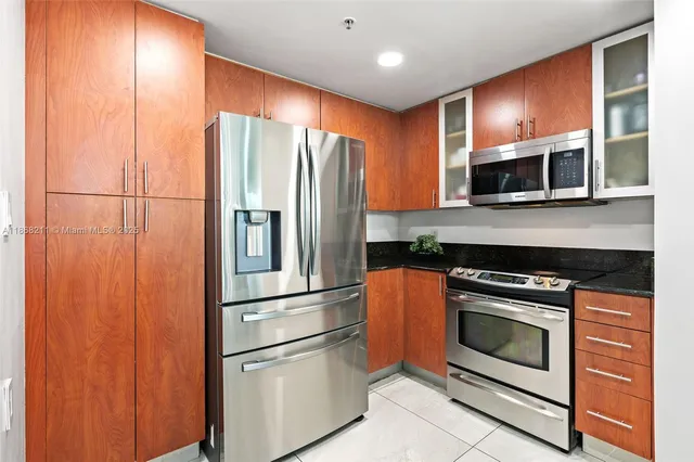 a kitchen with granite countertop stainless steel appliances and wooden cabinets