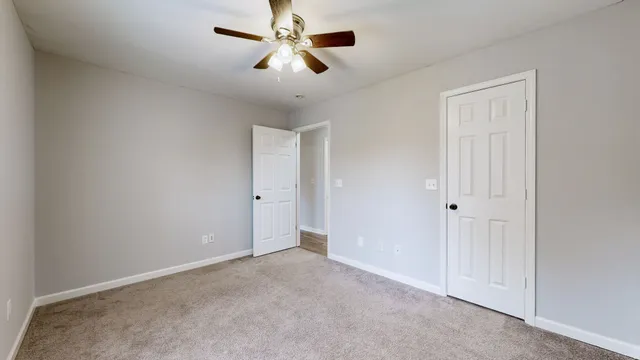 an empty room with chandelier fan