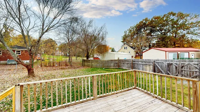 a view of a house with a yard and wooden fence