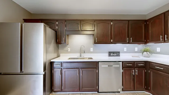 a kitchen with a sink a refrigerator and cabinets