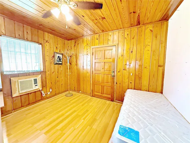 a spacious bedroom with a bed and wooden floor