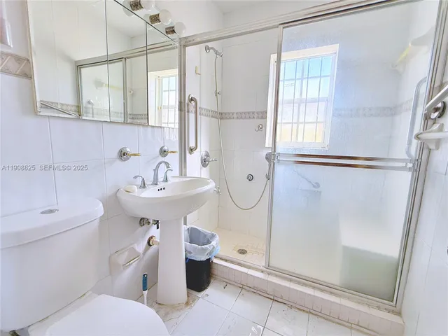 a bathroom with a sink toilet and shower