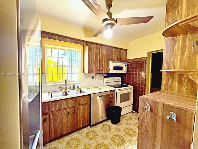 a kitchen that has a sink a refrigerator and a stove