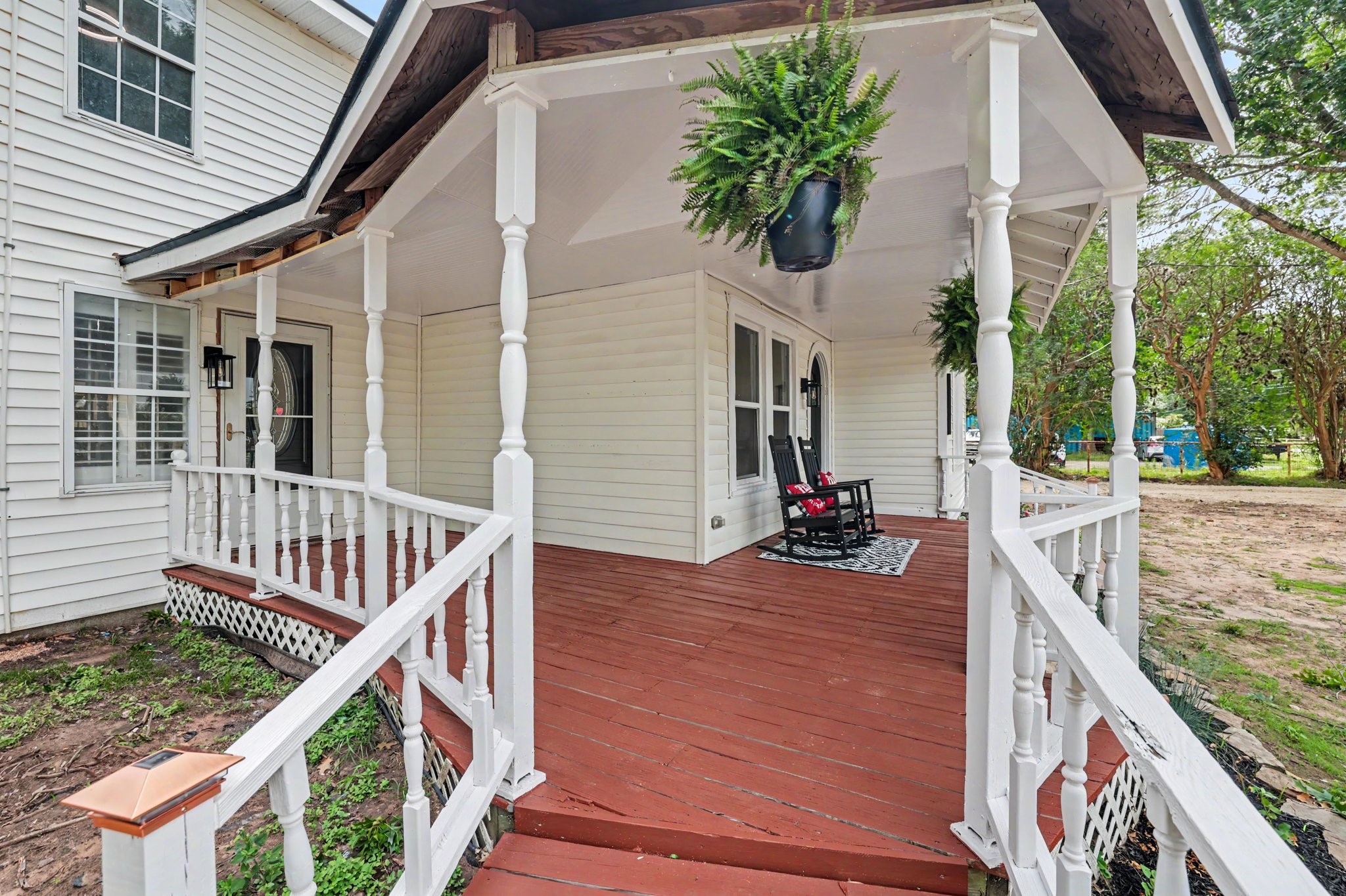 31730 Waller Tomball Road Waller, TX 77484 - Photo 9 of 50 Charming front porch with elegant white railings The wooden deck offers a welcoming space for relaxation, complemented by the home's classic siding and decorative trim.