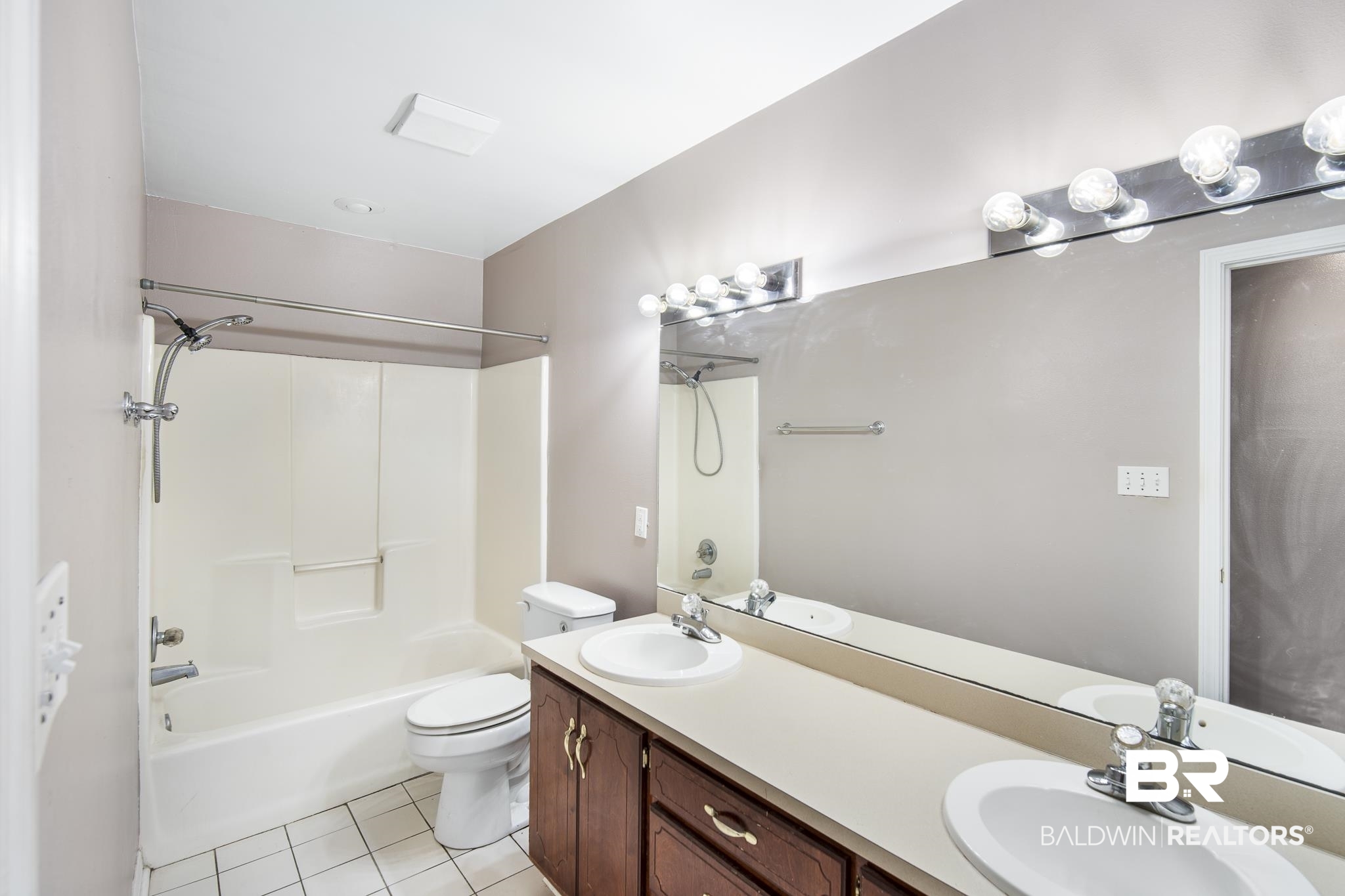103 Ann Street Daphne, AL 36527 - Photo 10 of 23 Bathroom featuring light tile patterned floors, double vanity, and tub / shower combination