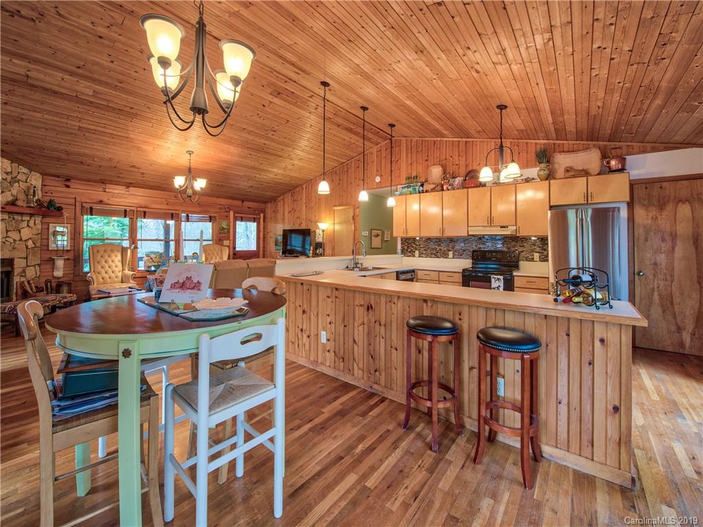 24 Thistle Ridge Clyde, NC 28721 - Photo 11 of 18 a kitchen with stainless steel appliances kitchen island granite countertop a table chairs and a chandelier
