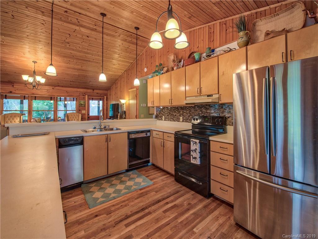 24 Thistle Ridge Clyde, NC 28721 - Photo 13 of 18 a kitchen with stainless steel appliances granite countertop a refrigerator a sink dishwasher a stove and white countertops with wooden floor