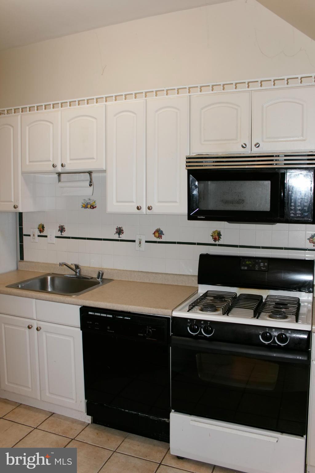642 8th Street Northeast Washington, DC 20002 - Photo 5 of 29 a kitchen with granite countertop a stove sink and cabinets