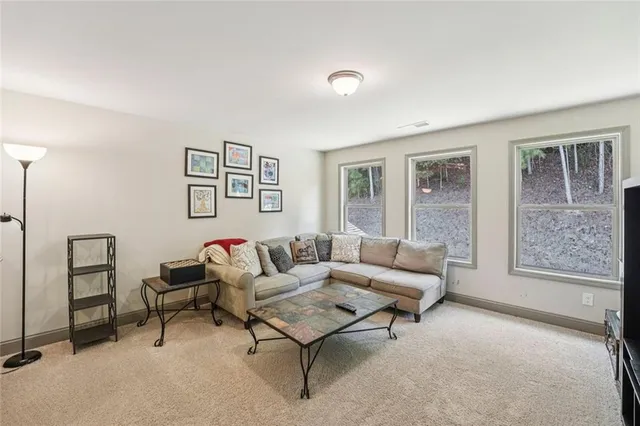 a living room with furniture and floor to ceiling windows