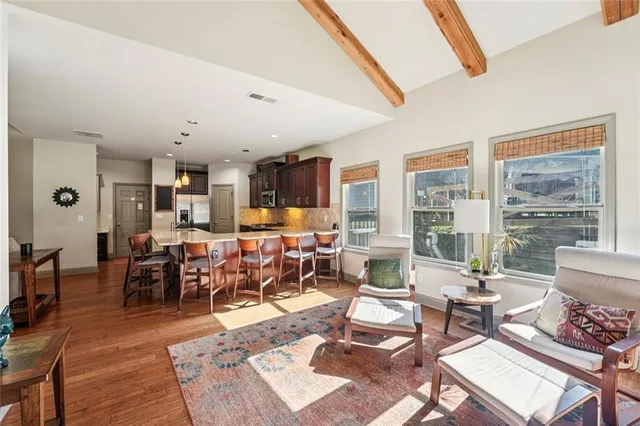 a dining room with wooden floor a chandelier a wooden table and chairs