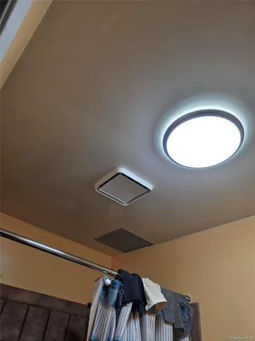 a view of a room with a chandelier fan