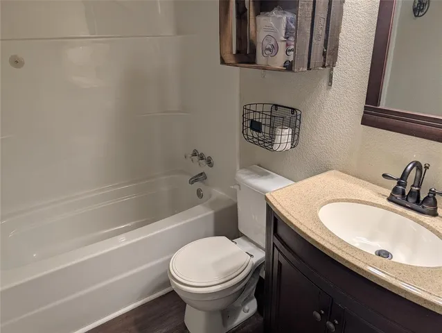 a bathroom with a granite countertop sink toilet and a bathtub