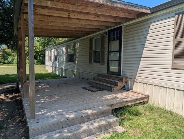 a view of backyard with large trees and plants