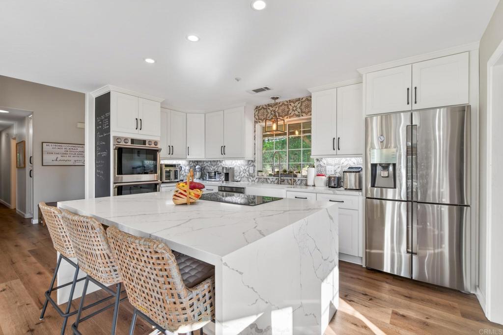 25350 Mesa Grande Road Santa Ysabel, CA 92070 - Photo 19 of 55 a kitchen with stainless steel appliances granite countertop a refrigerator a stove a sink a dining table and chairs