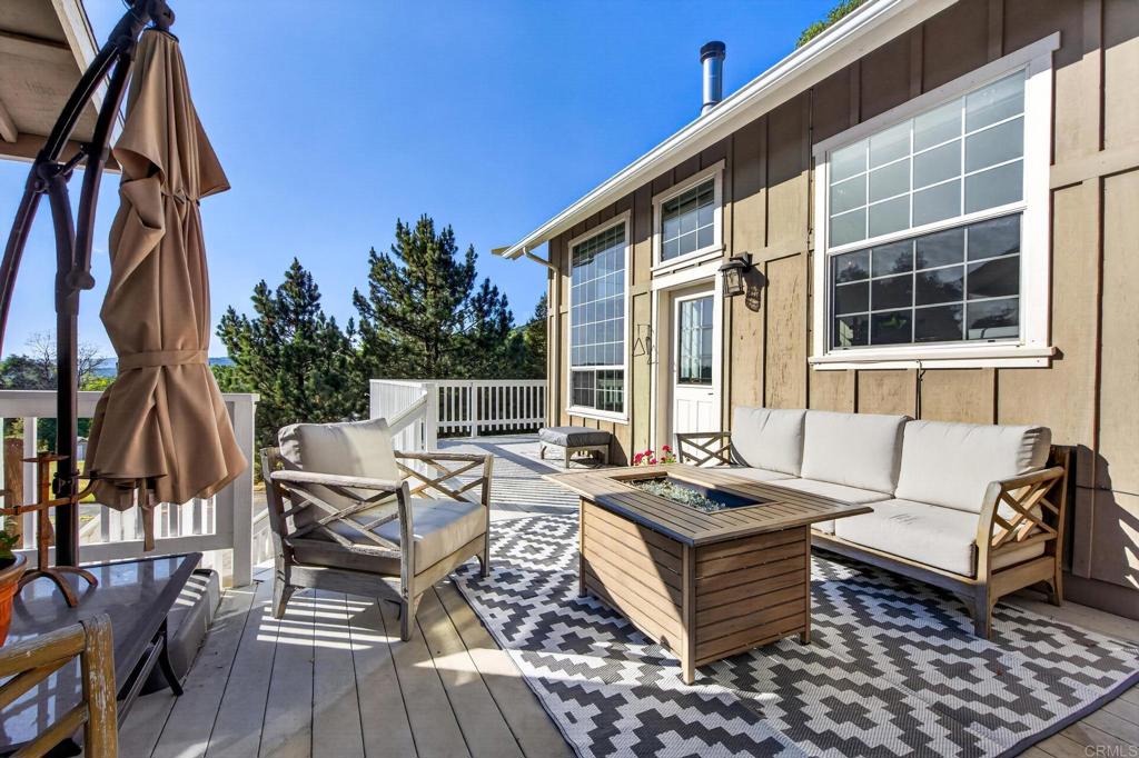 25350 Mesa Grande Road Santa Ysabel, CA 92070 - Photo 22 of 55 a view of a patio with couches table and chairs with wooden floor and fence