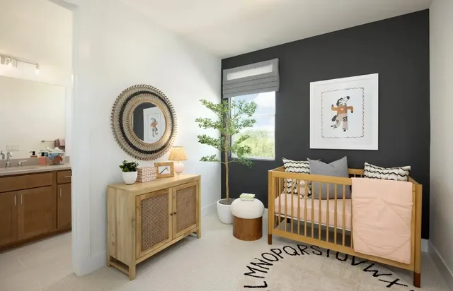 a bedroom with a baby crib a dresser and chair