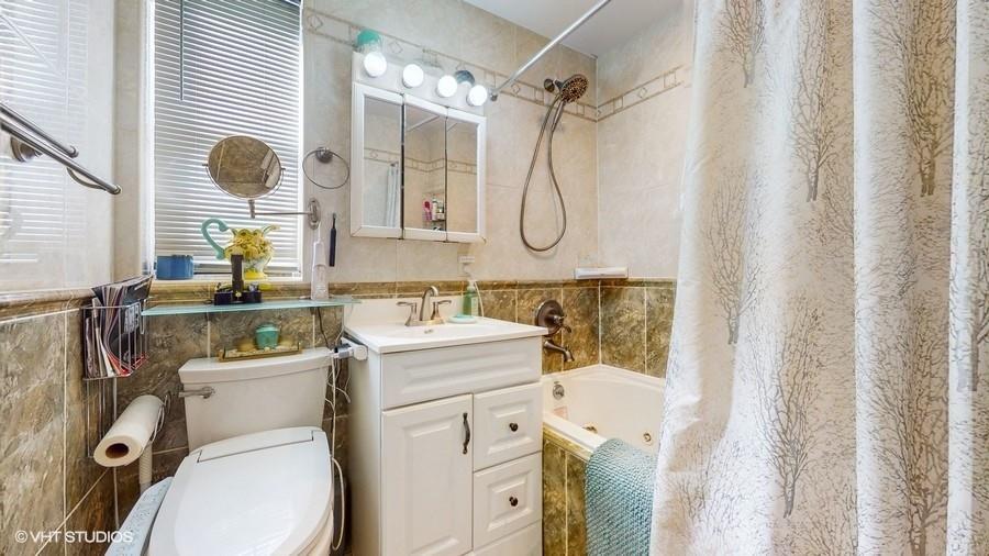 340 86th Street Brooklyn, NY 11209 - Photo 14 of 20 a bathroom with a granite countertop toilet sink and mirror