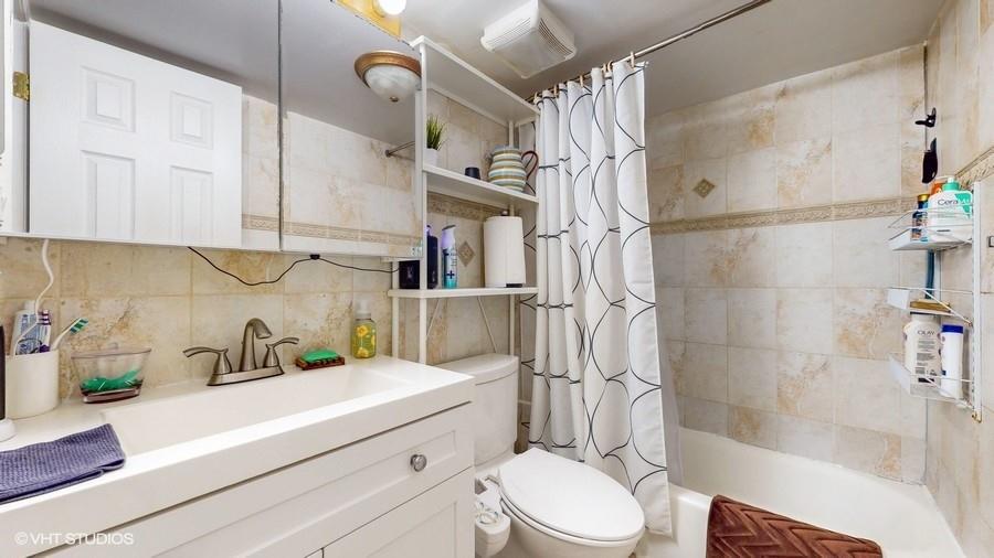 340 86th Street Brooklyn, NY 11209 - Photo 17 of 20 a bathroom with a sink a toilet and shower